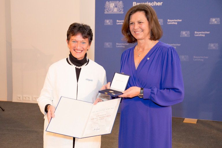 Inge Aures nimmt die Medaille von Landtagspräsidentin Ilse Aigner entgegen